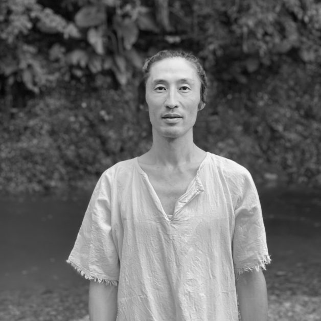 Koichi Toyama standing by a river in Taiwan (black and white portrait)